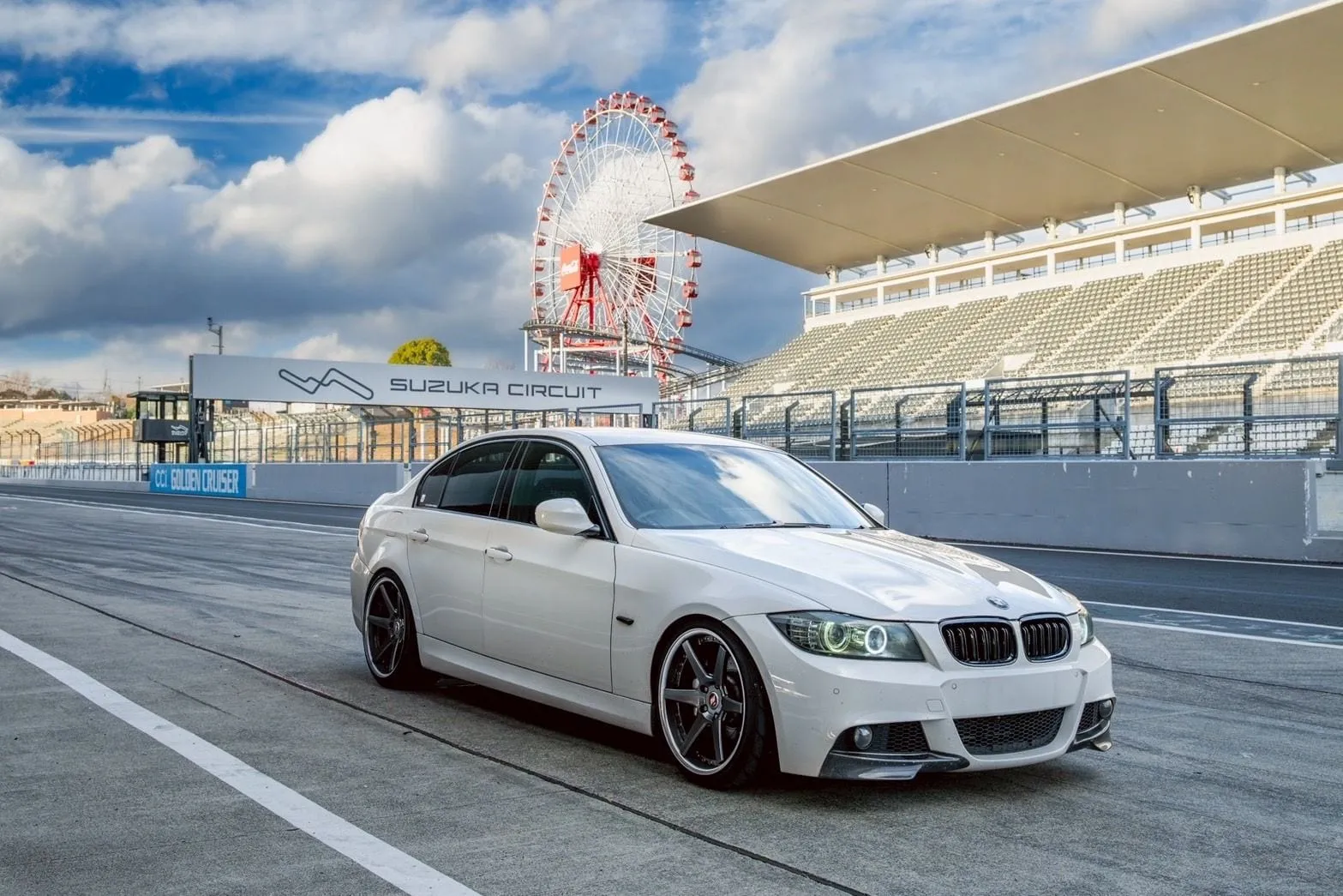 鈴鹿サーキットの看板と観覧車を背に停まるE90